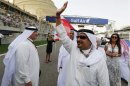 Bahrain's Crown Prince Salman bin Hamad al-Khalifa waves to spectators as he arrives before the Bahrain F1 Grand Prix at the Sakhir circuit
