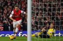 Arsenal's striker Olivier Giroud (L) scores after tackling Southampton's goalkeeper Artur Boruc during an English Premier League football match at the Emirates Stadium in London on November 23, 2013