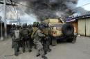 Members of the Philippine national police special forces take cover as they move toward enemy positions during a fire fight with Muslim rebels in Zamboanga City on September 12, 2013