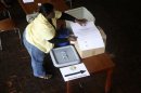 A Zimbabwean election official prepares voting material at a polling centre in Harare
