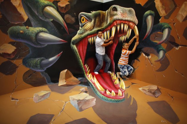 Man with his son pose for a photograph in front of a 3D painting at the 2012 Magic Art Special Exhibition in Hangzhou