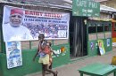 Children walk past a banner showing candidate Baidy Aribot in Conakry on August 30, 2013