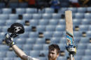 New Zealand's Jimmy Neesham raises his bat and helmet after scoring a century against West Indies during the second day of their first cricket Test match in Kingston, Jamaica, Monday, June 9, 2014. (AP Photo/Arnulfo Franco)