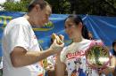 FILE - In this July 3, 2012, file photo, hot-dog eating champions Joey Chestnut, left, and Sonya "The Black Widow" Thomas pose for photographers at City Hall Park in New York, during a weigh-in for contestants in the annual Coney Island Fourth of July international hot-dog eating contest. The pair aim to take the crowns again at the annual Fourth of July contest on Coney Island.(AP Photo/Kathy Willens, File)