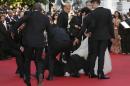 CORRECTS TO REMOVE REFERENCE TO DJIMON HOUNSOU AT LEFT Security run toward an unidentified man who ran unauthorized onto the red carpet during arrivals for the screening of How to Train Your Dragon 2 at the 67th international film festival, Cannes, southern France, Friday, May 16, 2014. (AP Photo/Alastair Grant)