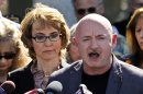 FILE - In this March 6, 2013 file photo, former Rep. Gabrielle Giffords, left, listens to her husband Mark Kelly, right, during a return to the supermarket where she was wounded in a rampage two years ago in Tucson, Ariz. Kelly went to a Tucson gun store a week ago to buy a .45-caliber handgun and a military-style rifle the day before the appearance. It didn't take long for the purchase to draw criticism from gun-rights supporters. (AP Photo/Ross D. Franklin, File)