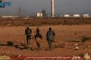 An image taken from jihadist media outlet Wilayat Trablus on June 9, 2015 allegedly shows Islamic State group fighters running towards what they say is a power plant in the southern Libyan city of Sirte