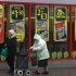 Women walk past offers advertised in the windows of a supermarket near Manchester