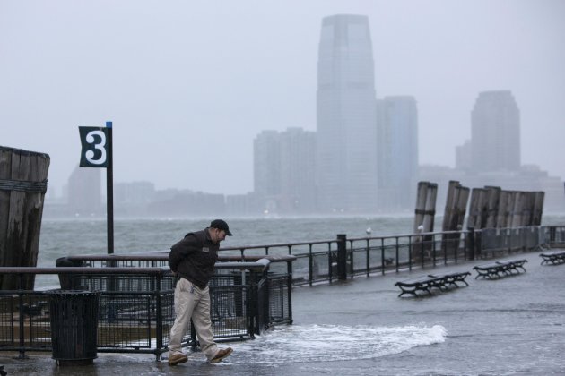 A man walks out of rising water in downtown Manhattan as Hurricane Sandy makes its approach in New York