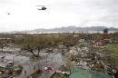 Helicopters hover over the damaged area after super Typhoon Haiyan battered Tacloban city
