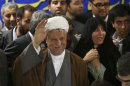 In this Saturday, May 11, 2013 photo, former President Akbar Hashemi Rafsanjani, waves to media, as he registers his candidacy for the upcoming presidential election, while his daughter Fatemeh, smiles at second right, at the election headquarters of the interior ministry in Tehran, Iran. On Saturday Rafsanjani's made a last minute surprise decision to enter Iran's presidential election process, which now includes more than 680 hopefuls and will culminate June 14 with just a handful of names on the ballot to succeed Mahmoud Ahmadinejad. In one of his first statements since joining the race, Rafsanjani spoke in general terms Sunday of seeking a new ``economic and political'' rebirth in a time of ``foreign threats and sanctions.'' (AP Photo/Ebrahim Noroozi)