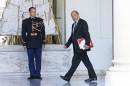 French Defense Minister Jean-Yves Le Drian walks in the lobby of the Elysee Palace on his way to a special defense meeting, on the country's mission against the Islamic State group, with French President Francois Hollande in Paris, Wednesday Oct. 1, 2014. (AP Photo/Remy de la Mauviniere)