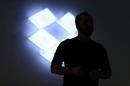 Drew Houston, Chief Executive Officer and founder of Dropbox, stands in front of the company's logo at an announcement event in San Francisco
