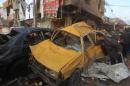 Iraqis inspect the scene of a car bomb attack in the Sadr City district of Baghdad on December 5, 2014