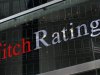A flag is reflected on the window of the Fitch Ratings headquarters in New York