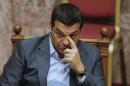 Greek Prime Minister Alexis Tsipras reacts as he attends a parliamentary session in Athens