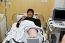 In this photo released by the government-run Bolivian Information Agency, Bolivia's President Evo Morales smiles after knee surgery to correct a soccer injury, in the recovery room of a clinic in Cochabamba, Bolivia, Sunday, June 12, 2016. Morales ruptured ligaments in his left knee during a game of indoor soccer marking the inauguration of a sporting complex financed by his government in a city near La Paz. (Reynaldo Zaconeta/Bolivian Information Agency via AP)