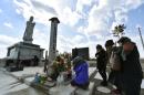 People pray for tsunami victims at a cenotaph on the coastal area of Arahama district in Sendai, Miyagi Prefecture on March 11, 2015