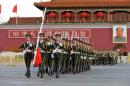 Paramilitary policemen carry a Chinese national flag as they march out of the Tiananmen Gate, during a flag raising ceremony on China's National Day, in Beijing