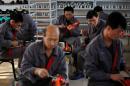 North Korean workers make soccer shoes inside a temporary factory at a rural village on the edge of Dandong