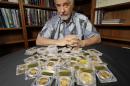David Hall, co-founder of Professional Coin Grading Service, poses with some of 1,427 Gold-Rush era U.S. gold coins, at his office in Santa Ana, Calif., Tuesday, Feb. 25, 2014. A California couple out walking their dog on their property stumbled across the modern-day bonanza: $10 million in rare, mint-condition gold coins buried in the shadow of an old tree. Nearly all of the 1,427 coins, dating from 1847 to 1894, are in uncirculated, mint condition, said Hall, who recently authenticated them. Although the face value of the gold pieces only adds up to about $27,000, some of them are so rare that coin experts say they could fetch nearly $1 million apiece. (AP Photo/Reed Saxon)