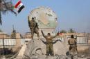 A member of the Iraqi security forces holds an Iraqi flag at a government complex in the city of Ramadi