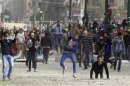 Demonstrators against Egypt's President Mursi throw stones at riot police during clashes in Cairo