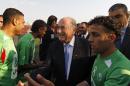 FILE - In this May 15, 2011 file photo, FIFA president Joseph S. Blatter, center, greets members of the Palestinian refugee camp team from Amari before their friendly match against the Senegalese club team Dakar, in the West Bank town of Aram, near Ramallah. Israel's sports minister has written to FIFA President Sepp Blatter, defending her country's travel restrictions on some Palestinian soccer players. The Palestine Football Association has called on FIFA to suspend Israel unless it lifts travel restrictions on his players. (AP Photo/Tara Todras-Whitehill, file)