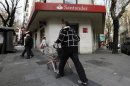 A man with a trolley walks past a Santander bank branch in Madrid