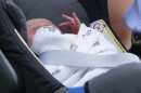 FILE - This is a Tuesday July 23, 2013 file photo Prince George of Cambridge lays in a car seat as his parents, Britain's Prince William and Kate, Duchess of Cambridge leave St. Mary's Hospital exclusive Lindo Wing, in London where the Duchess gave birth on Monday July 22. Be patient everyone: Your order will be processed, but like little Prince George, you will have to get in line. It took perhaps 45 seconds for the heir to the throne to be carried from St. Mary's Hospital in his car seat to be settled in the black royal Land Rover last week. But it was long enough for the world's photographers to capture his tiny hands emerging from a cotton swaddle printed with little birds. Distinctive little birds. (AP Photo/Alastair Grant, file)