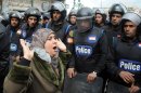 A woman reacts as she stands before riot policemen separating opponents of Egyptian President Mohammed Morsi clashing with Islamist supporters of the president in Alexandria, Egypt, Friday, Dec. 21, 2012. Thousands of Islamists clashed with their opponents Friday in Egypt's second largest city, Alexandria, on the eve of the second leg of voting on the country's contentious constitution that has deeply polarized the nation.(AP Photo)