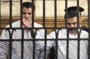 Egyptian policemen Awad Suleiman and Mahmoud Salah react in dock during trial in court in Alexandria