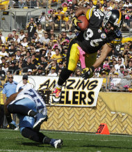 El receiver de los Steelers de Pittsburgh Hines Ward (86) salta hacia la zona de anotación por encima del safety de los Titans de Tenesí Michael Griffin, en Pittsburgh el domingo 9 de octubre de 2011. (Foto AP/Gene J. Puskar)