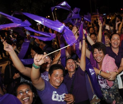 People celebrate after legislators pass a landmark birth control bill in Manila on December 17, 2012
