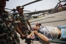 A man injured in Saturday's earthquake is carried on a stretcher after being evacuated in an Indian Air Force helicopter, in Kathmandu, Nepal, Friday, May 1, 2015. The 7.8-magnitude earthquake shook Nepal's capital and the densely populated Kathmandu valley on Saturday devastating the region and leaving tens of thousands shell-shocked and sleeping in streets. (AP Photo/Niranjan Shrestha)