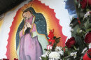 Photos and flowers honoring late singer Jenni Rivera, placed by fans next to religious images, are seen at the cemetery where her mother is buried in Hermosillo, northern Mexico, Monday, Dec. 10, 2012. U.S. authorities confirmed Monday that Rivera, a U.S.-born singer whose soulful voice and openness about her personal troubles made her a Mexican-American superstar, was killed in a plane crash early Sunday in northern Mexico. (AP Photo/Baldemar De Los Llanos)
