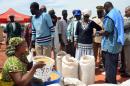 Ertharin Cousin (4th R), director of the UN World Food programme, watches food being distributed at a displaced persons camp at Mopti, Mali on March 18, 2013