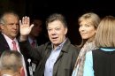 Colombian President Juan Manuel Santos waves to the media with his wife Maria Clemencia upon his arrival at a hospital for surgery in Bogota