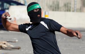 A masked Palestinian youth throws stones towards Israeli&nbsp;&hellip;