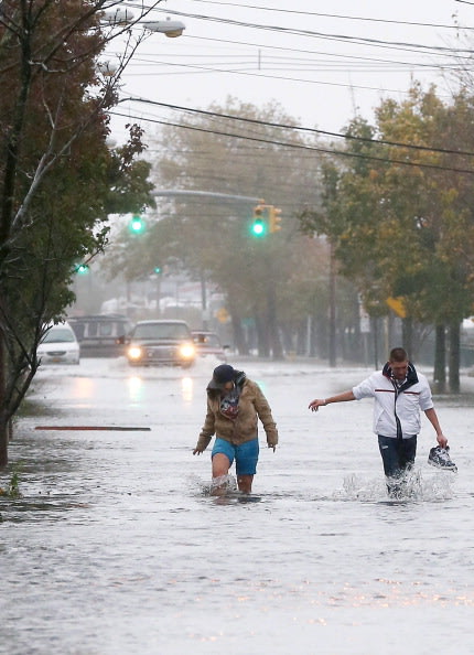 رجلان يحاولان السير وسط الفيضان