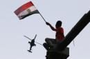 A man waves Egyptian national flag as military helicopter circles over Tahrir Square, after swearing-in ceremony of president elect Sissi, in Cairo