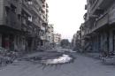 A general view shows a deserted street filled with debris of damaged buildings in Deir al-Zor