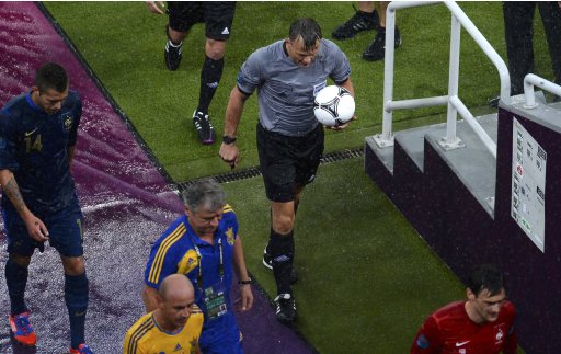 Match referee Bjorn Kuipers of Netherlands (R) with the France's and Ukraine's teams leave the picth due to heavy rain during their Group D Euro 2012 soccer match at Donbass Arena in Donetsk