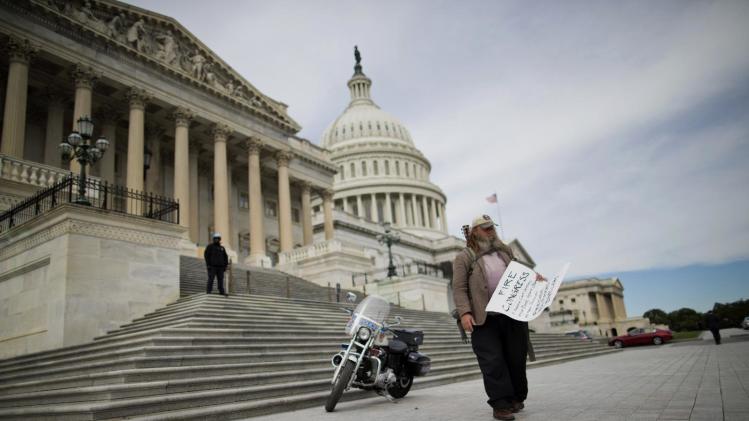 FILE - This Oct. 8, 2013 file photo shows Rick Hohensee of Washington carrying a &quot;Fire Congress&quot; sign near the House steps on Capitol Hill in Washington. Americans enter 2014 with a profoundly negative view of their government, expressing little hope that elected officials can or will solve the nation’s biggest problems, a new poll finds. Half say America’s system of democracy needs either “a lot of changes” or a complete overhaul, according to the new poll, conducted by the AP-NORC Center for Public Affairs Research. Just 1 in 20 says it works well and needs no changes. (AP Photo/ Evan Vucci, File)