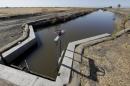 In this photo taken July 15, 2015, water flows down a canal near Byron, Calif. The California State Water Resources Control Board said it's proposing a fine of $1.5 million against the Byron-Bethany Irrigation District for allegedly taking water from a pumping plant after it was warned that there was not enough water. (AP Photo/Rich Pedroncelli)