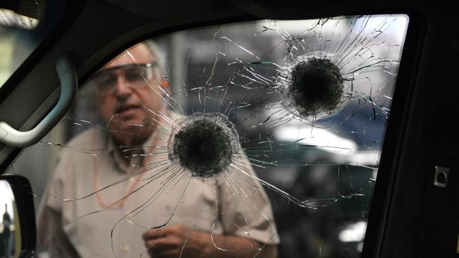 A worker checks the re-inforced windows of a car at a garage making armoured cars in Caracas, on October 21, 2014