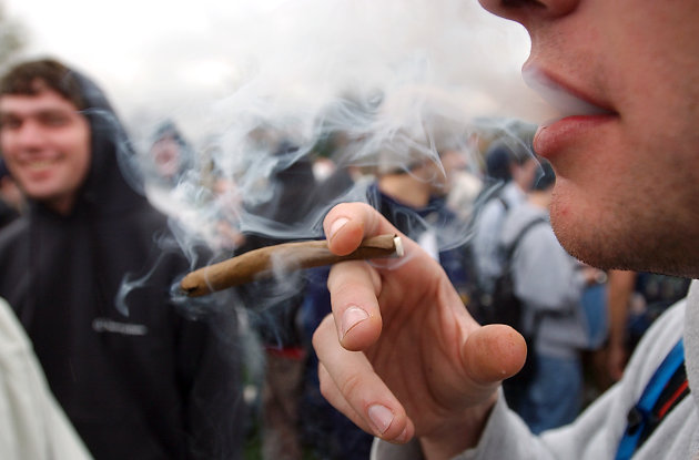 FILE - In an April 20, 2005 file photo, a University of Colorado freshman, who did not want to be identified, joins a crowd smoking marijuana during a "420" gathering at Farrand Field at the University of Colorado in Boulder, Colo. People who started using marijuana persistently before age 18 risk losing some of their IQ by the time they're 38, a long-running study says. In contrast, even long-term chronic users who started after age 18 showed no such effect, suggesting the drug holds some particular toxicity for the developing brain. (AP Photo/Longmont Daily Times-Call, Richard M. Hackett, File) MANDATORY CREDIT, MAGS OUT, NO SALES