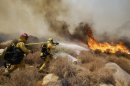 Firefighters battle a wildfire, Thursday, Aug. 8, 2013, in Cabazon, Calif. About 1,500 people have fled and three are injured as a wildfire in the Southern California mountains quickly spreads. Several small communities have evacuated. (AP Photo/Jae C. Hong)