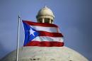 FILE - In this Wednesday, July 29, file 2015 photo, the Puerto Rican flag flies in front of Puerto Rico's Capitol as in San Juan, Puerto Rico. On Monday, April 11, 2016, Puerto Rico released a new proposal to restructure part of its $70 billion debt to buy time to implement a fiscal growth plan as multimillion-dollar payments loom for a U.S. territory facing dwindling cash reserves. (AP Photo/Ricardo Arduengo, File)