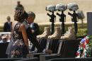 U.S. President Barack Obama places a challenge coin on a memorial as he and first lady Michelle Obama pay their respects for the dead soldiers at the conclusion of service in Fort Hood